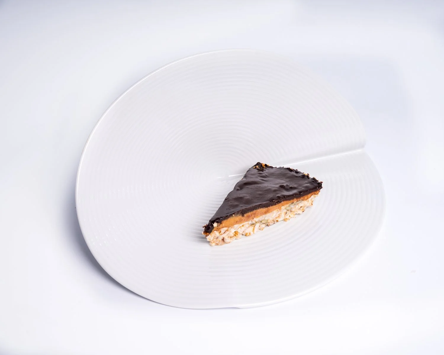 Salted Caramel Chocolate Tart — Raw almond base, dark chocolate ganache, sea salt.