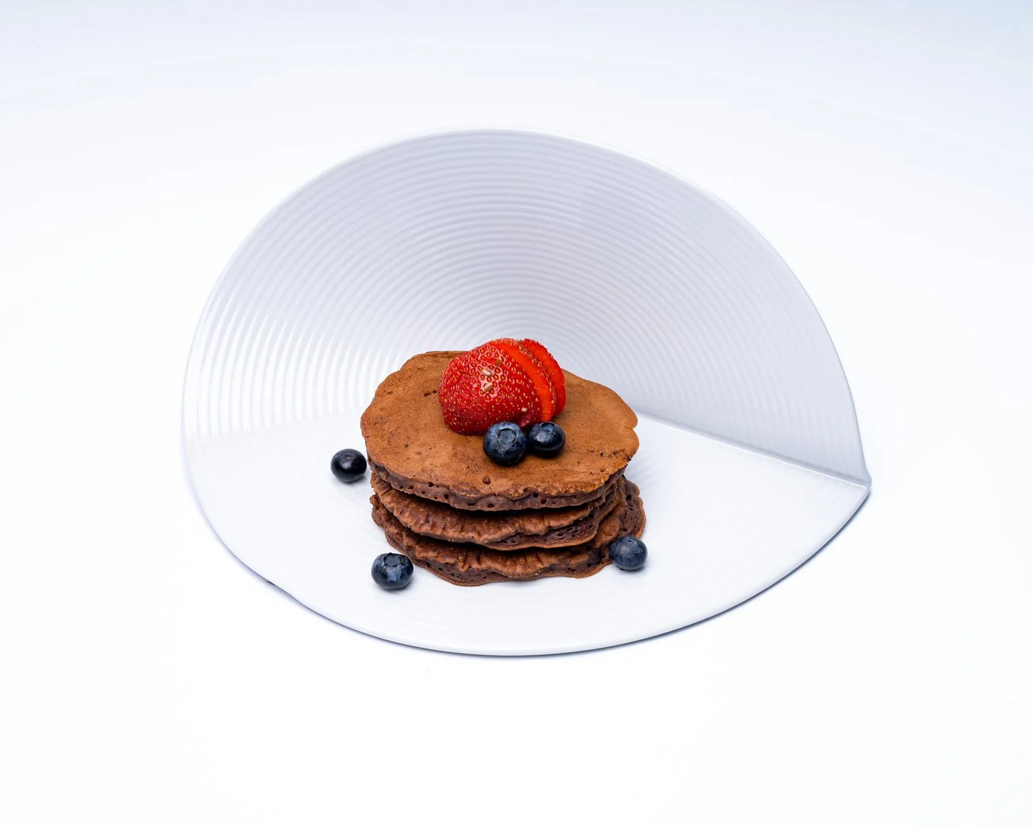 Cacao Protein Pancakes — Cacao oat pancakes, strawberries and blueberries.